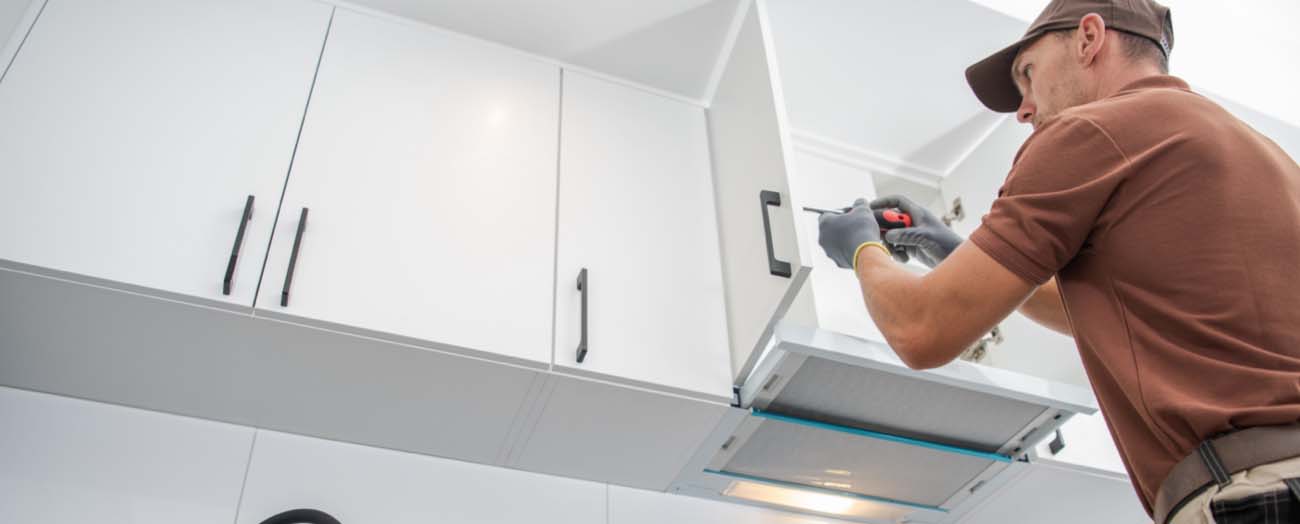 Man Installing White Cabinets